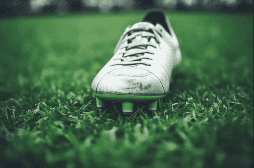 A soccer shoe in the grass